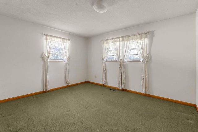 unfurnished room featuring carpet and a textured ceiling