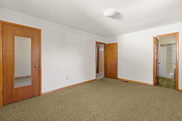 unfurnished bedroom with carpet flooring and ensuite bath