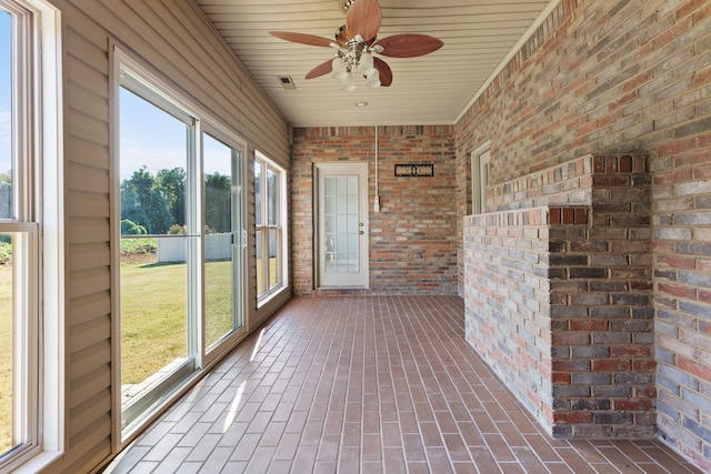 unfurnished sunroom with ceiling fan and wooden ceiling