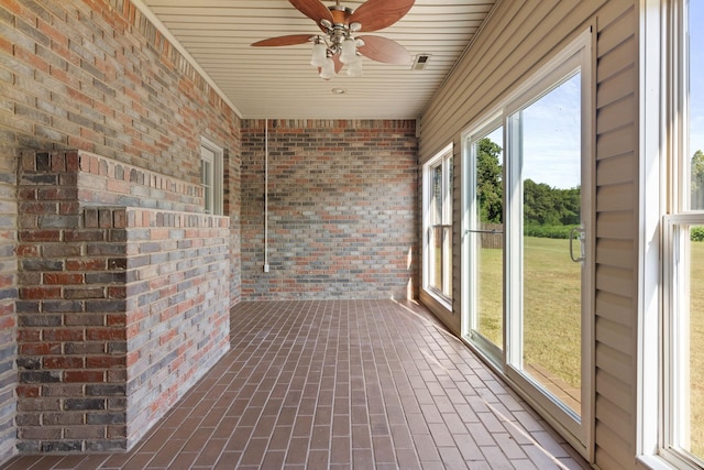 unfurnished sunroom with ceiling fan