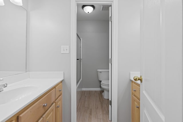 bathroom featuring vanity, toilet, and wood-type flooring