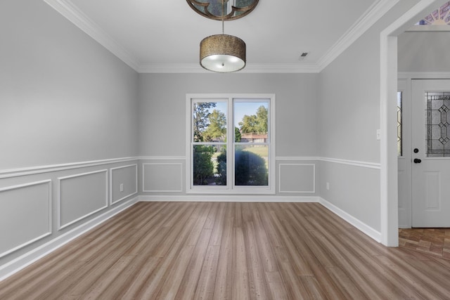 empty room featuring crown molding and light hardwood / wood-style flooring