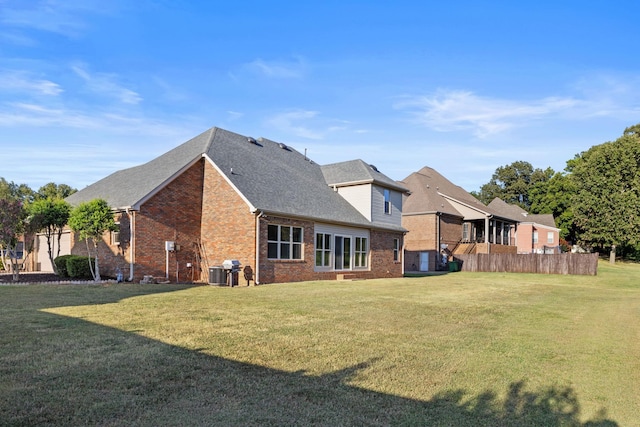 back of property featuring central AC and a lawn