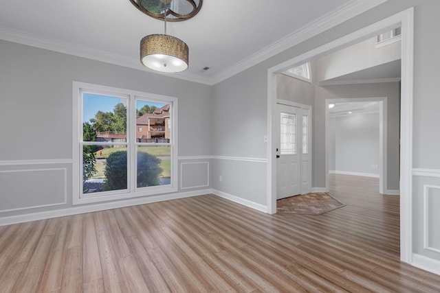 unfurnished room featuring crown molding, plenty of natural light, and light hardwood / wood-style floors