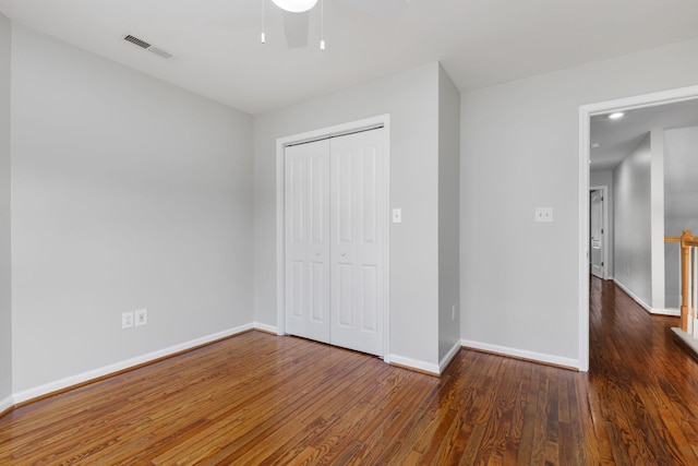 unfurnished bedroom featuring a closet and dark wood-type flooring