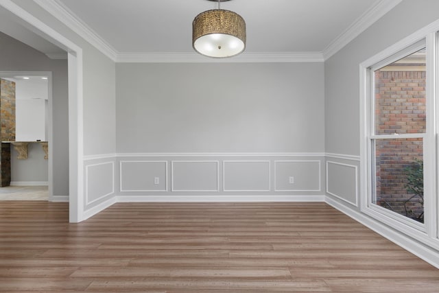 spare room featuring light wood-type flooring and ornamental molding