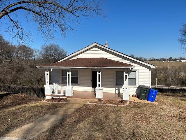 view of front of property with covered porch and a front lawn