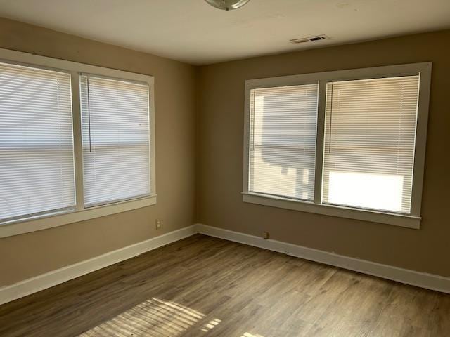 unfurnished room with hardwood / wood-style flooring