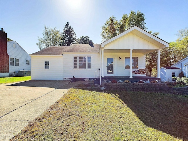 ranch-style house with covered porch, a shed, and a front yard