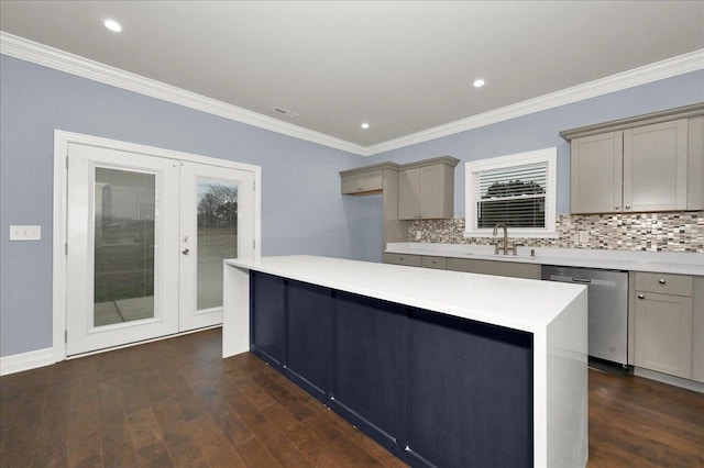 kitchen featuring decorative backsplash, stainless steel dishwasher, sink, a center island, and gray cabinets