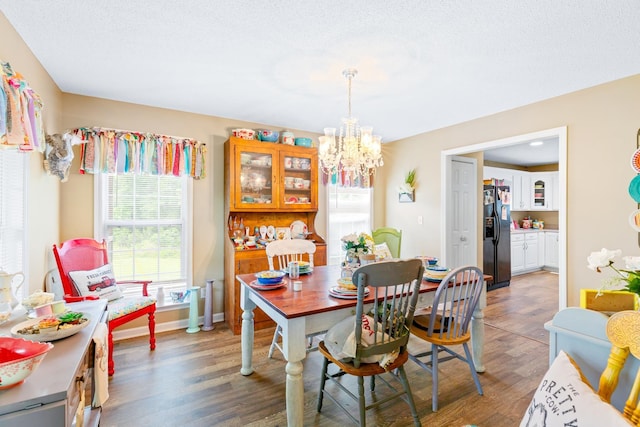  - dining space featuring a chandelier, plenty of natural light, light wood finished floors, and baseboards