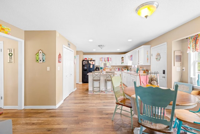  - dining area featuring light wood-style flooring, baseboards, and recessed lighting