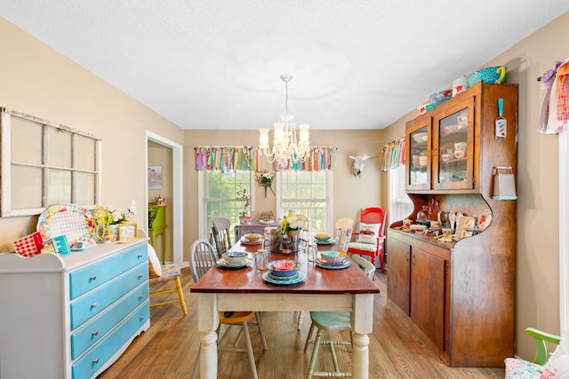  - dining area with light wood-style flooring and a chandelier