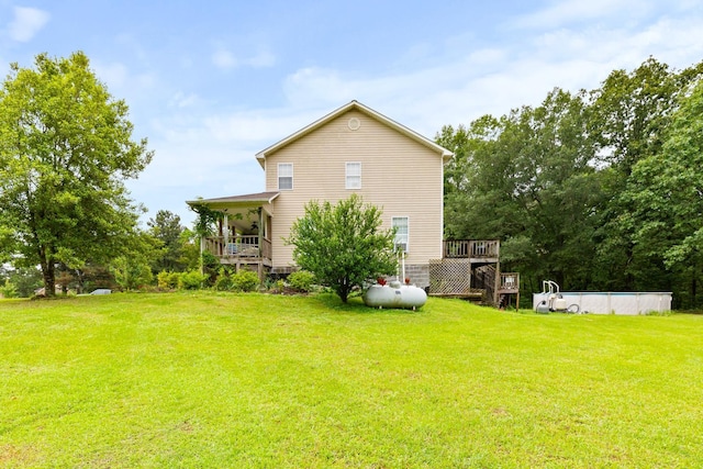  - rear view of house with a lawn, an outdoor pool, and a deck