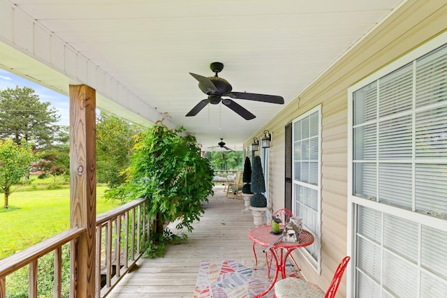  - porch with a ceiling fan and a lawn