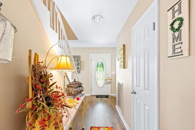  - entryway featuring wood finished floors, a textured ceiling, and baseboards