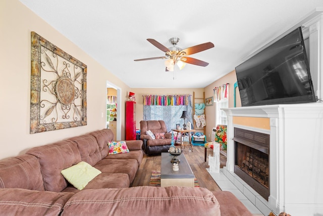  - living area featuring a ceiling fan, a fireplace with flush hearth, and wood finished floors