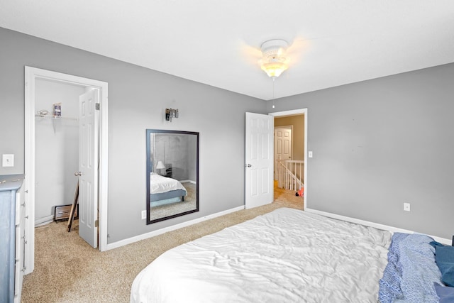  - bedroom with light colored carpet, a walk in closet, a closet, baseboards, and ceiling fan