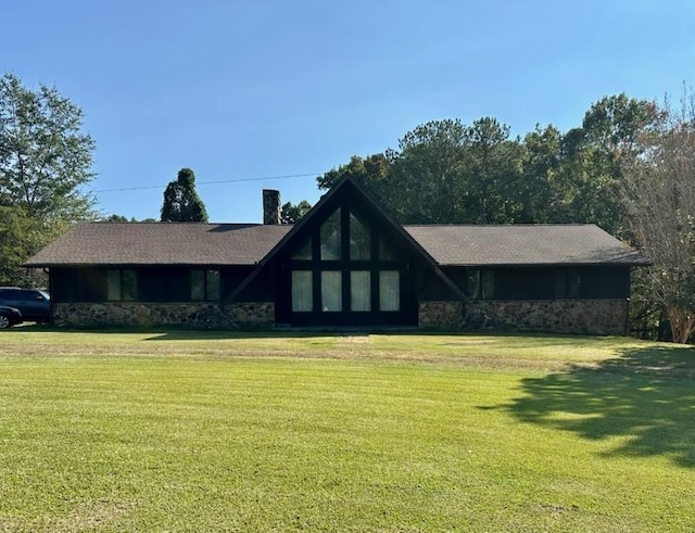 - view of front of property with stone siding and a front yard