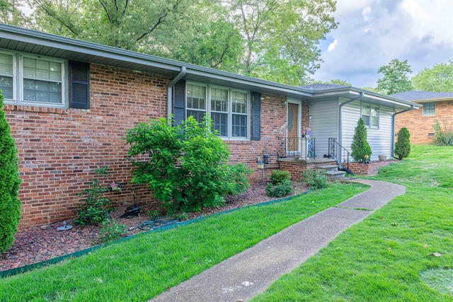  - single story home with a front yard and brick siding