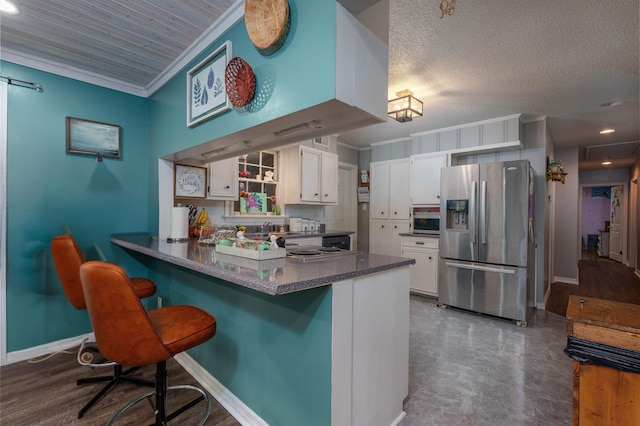  - kitchen featuring stainless steel fridge, white cabinets, ornamental molding, a peninsula, and a breakfast bar area