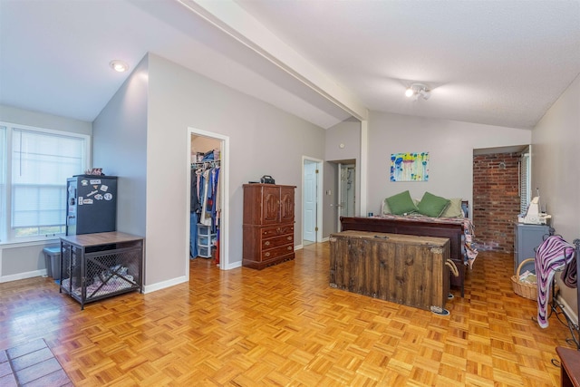  - bedroom with lofted ceiling, a walk in closet, baseboards, and a closet