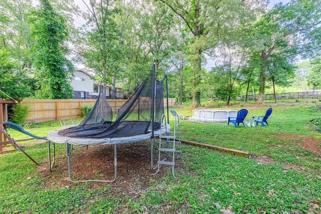  - view of yard featuring a trampoline and an outdoor pool