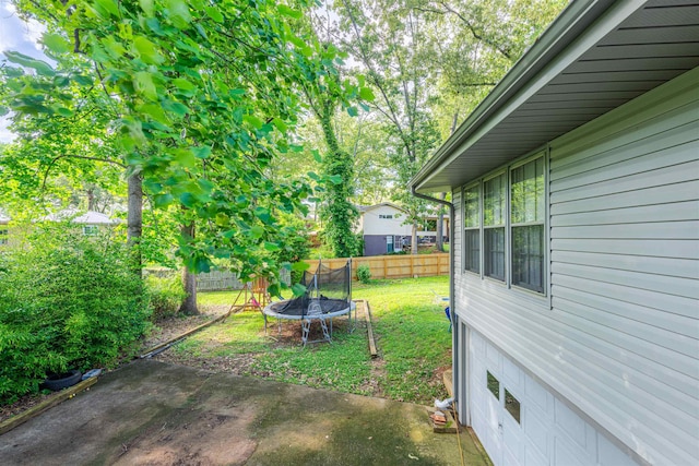  - view of yard featuring a trampoline and a patio