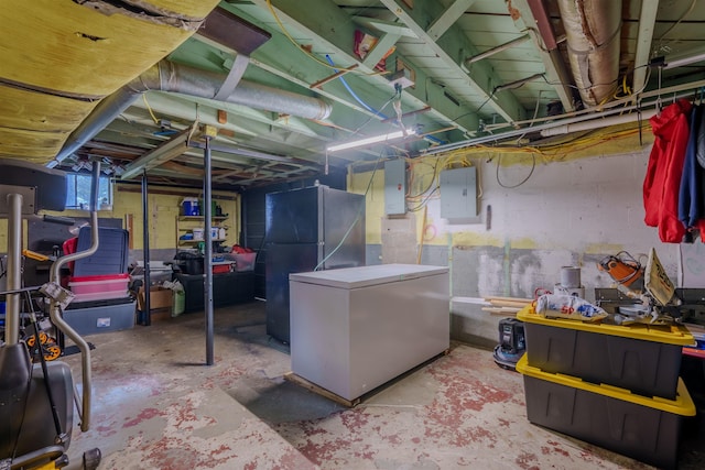  - basement featuring refrigerator, freestanding refrigerator, and electric panel