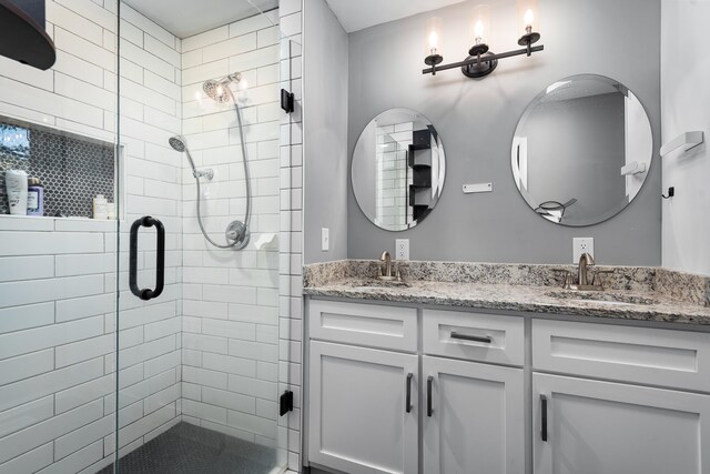 full bathroom featuring double vanity, a stall shower, and a sink