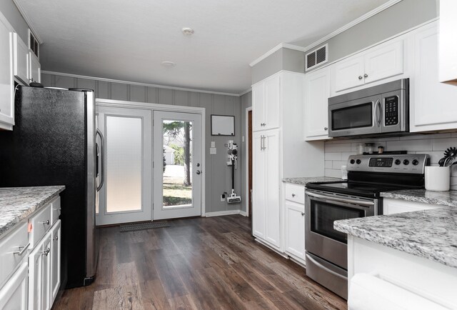 kitchen featuring visible vents, appliances with stainless steel finishes, white cabinets, and crown molding