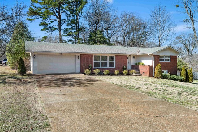 ranch-style house featuring a garage, concrete driveway, and brick siding