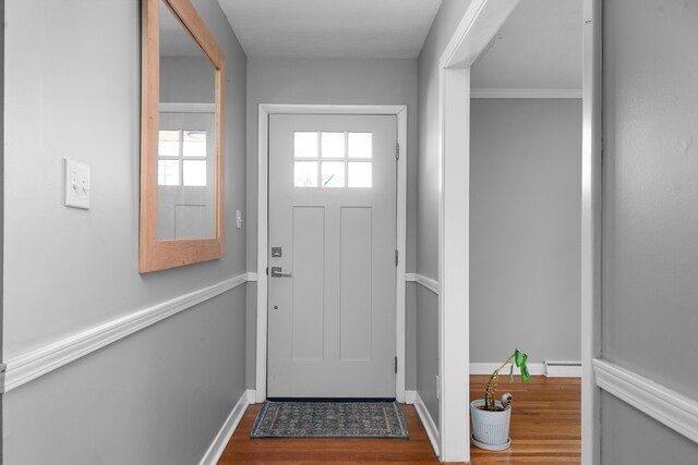 entryway with a baseboard radiator, baseboards, and dark wood-type flooring