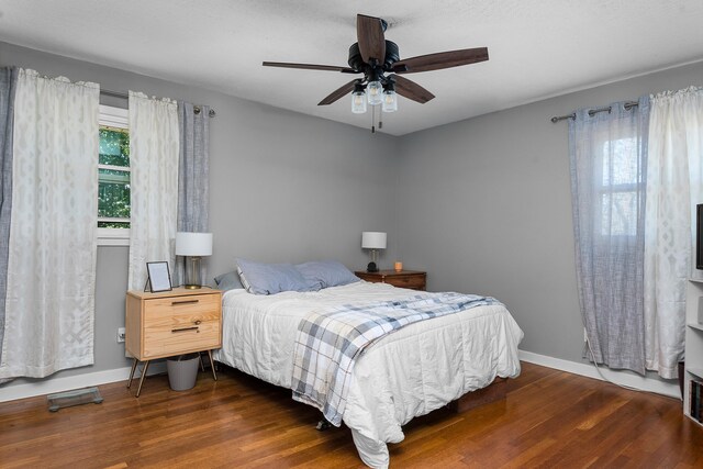 bedroom featuring a ceiling fan, baseboards, and wood finished floors