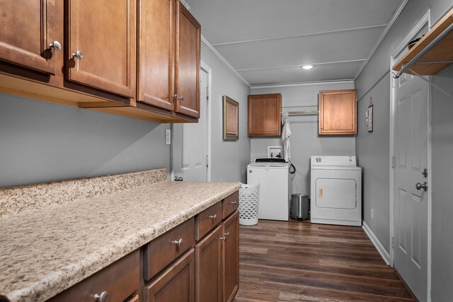 laundry area with washing machine and dryer, dark wood-style flooring, baseboards, ornamental molding, and cabinet space