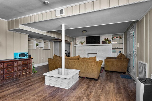 living area with a fireplace, wood finished floors, and visible vents