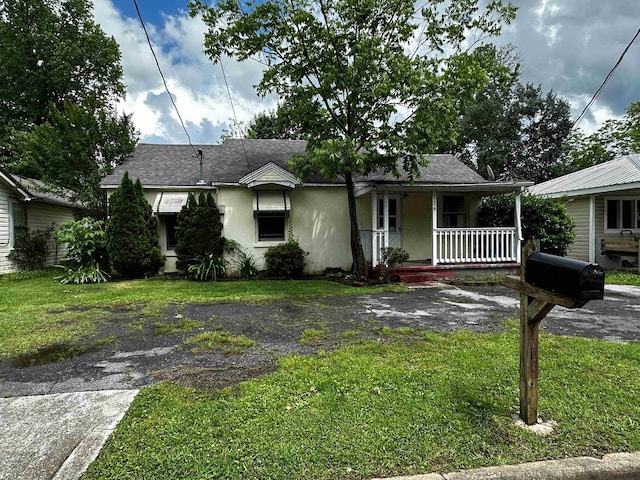 114 Mcnabb Rd SW, Cullman, AL - view of front of property with a porch, a front lawn, stucco siding, roof with shingles, and asphalt driveway