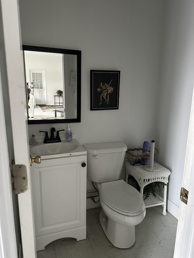 bathroom featuring tile patterned floors, vanity, and toilet