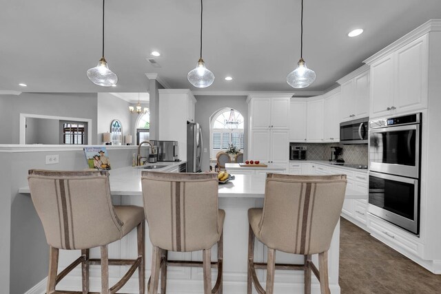  - kitchen featuring stainless steel appliances, a peninsula, recessed lighting, tasteful backsplash, and a kitchen breakfast bar