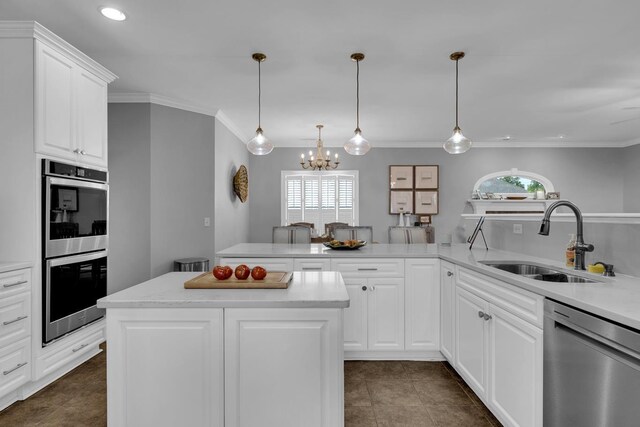  - kitchen with stainless steel appliances, a chandelier, plenty of natural light, recessed lighting, and light countertops