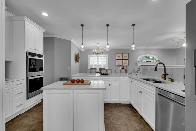  - kitchen with appliances with stainless steel finishes, ornamental molding, a chandelier, light countertops, and dark tile patterned flooring