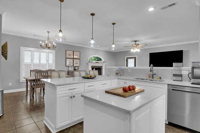  - kitchen featuring stainless steel dishwasher, ornamental molding, a kitchen island, ceiling fan, and a fireplace