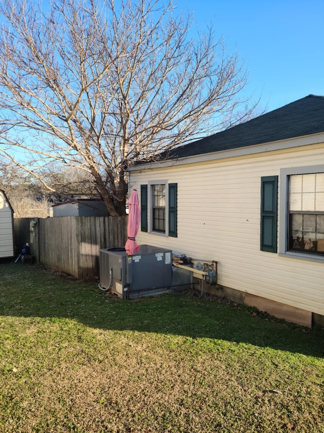 view of property exterior with central air condition unit and a yard