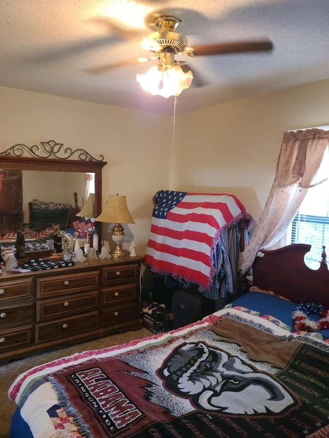 carpeted bedroom featuring a textured ceiling and ceiling fan