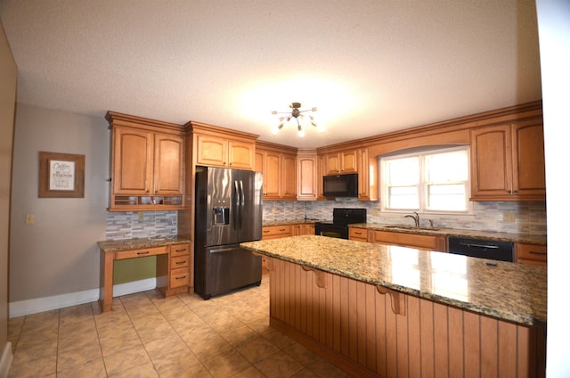 kitchen featuring sink, light stone counters, a kitchen breakfast bar, a notable chandelier, and black appliances