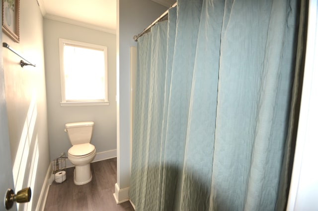 bathroom with crown molding, wood-type flooring, and toilet