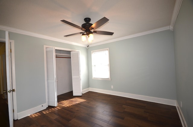 unfurnished bedroom with dark wood-type flooring, ceiling fan, ornamental molding, and a closet