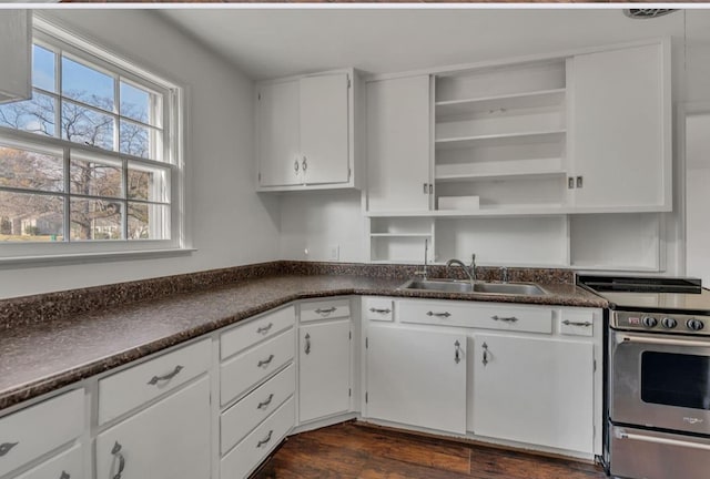 kitchen with white cabinetry, sink, stainless steel stove, and dark hardwood / wood-style flooring