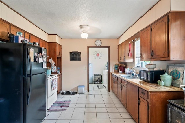 kitchen with black appliances, light tile patterned floors, sink, and a textured ceiling