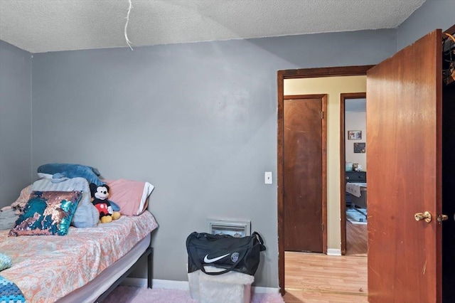 bedroom featuring hardwood / wood-style floors and a textured ceiling